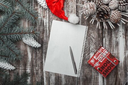 Old wooden background. Green fir branches. Christmas card, Christmas and New Year's Eve. Santa's Cap. Letter to Santa. Decorative items, gift. Xmas and Happy New Year composition. Flat lay, top viewの写真素材