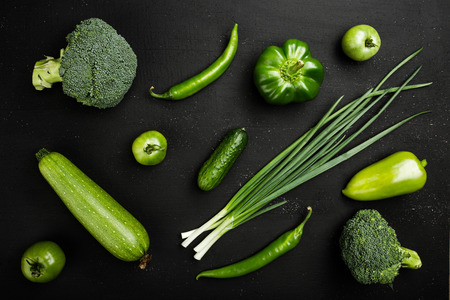 Fresh green vegetables on rustic dark wood background, top viewの写真素材