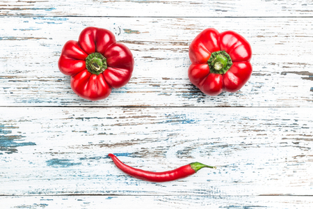 Composition of red peppers, vegetable smile. Top view on old white backgroundの写真素材