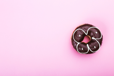 Chocolate glazed donut, top view over white background, isolated. With nutsの写真素材