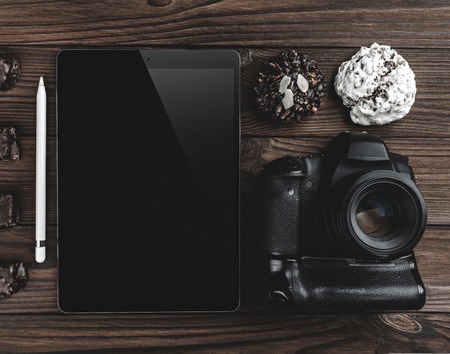 Professional camera, tablet and cookies on a wooden table, relaxing break at home concept. Top viewの写真素材