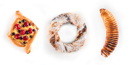 Fresh and tasty berry cake, a pretzel with sugar powder and banana in dough isolated over white backgroundの写真素材