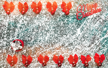 Red bows, red globes, decorative handmade tree toys and Merry Christmas sign, text, on gray, marble, stone background, view from top, above, flat, with space for text, Xmas greeting card.の写真素材