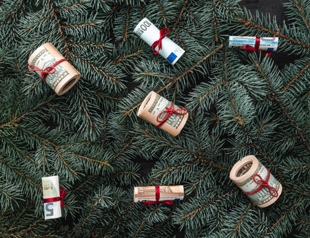 Winter background of fir branches. Money in the form of toys. Christmas card. Top view. Xmas...