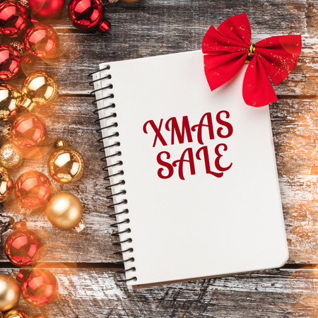 Christmas card. Old wood background, half full of baubles. And a notebook for a greeting message. Top view.の写真素材