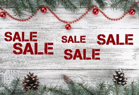 Xmas card. Old wooden Christmas background. Fir branches and cones. Red baubles and garlands. Top view. Sale text. Horizontally card.の写真素材
