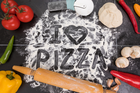 Ingredients for pizza, mushrooms, tomatoes, peppers garlic dough and flourの写真素材