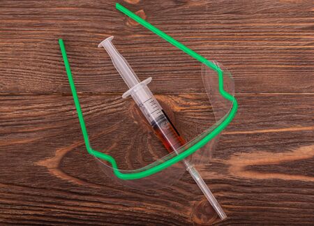 Protective glasses and a syringe with vaccine for immunization and prevention Coronavirus on wooden background. Medicine and healthcare conceptの写真素材