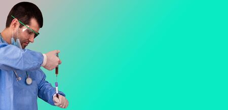 Concept of creating the vaccine against Covid-19. Doctor inserts serum from the syringe into a test tube with space for text on the labelの写真素材