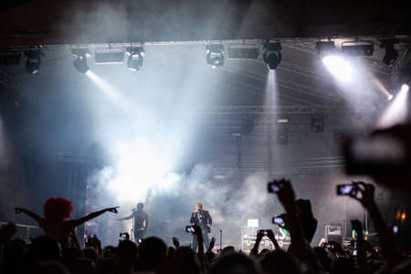 Lots of people filming with their cell phones at a concert at nightのeditorial素材