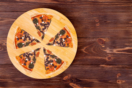 Five slices of tasty pizza with cherry tomatoes, spinach, mozzarella, feta, kalamata olive and...
