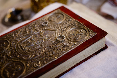 An old bible with two white gold rings on it. Canonical book for the church registration of marriage