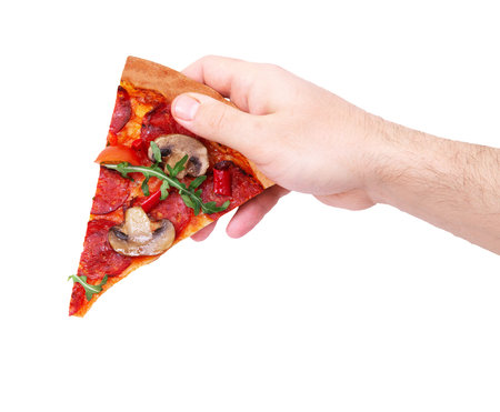Hot pizza slice with spicy salami, arugula, cherry tomatoes, mushrooms and texas spice mix, in man's...