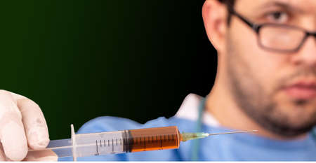 Doctor with syringe analyzing virus Covid-19 in research for vaccine, testing potential vaccine at the laboratory. Immunization and protection against the new Coronavirusの写真素材