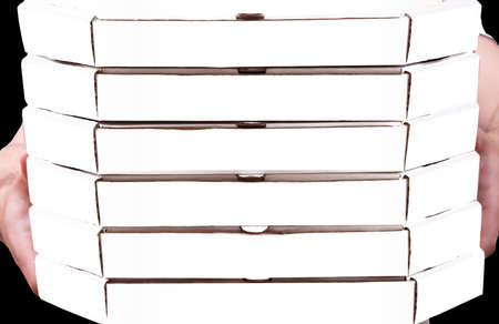 Pizza delivery, white cardboard pizza boxes held in the hands of a courier, isolated on black backgroundの写真素材