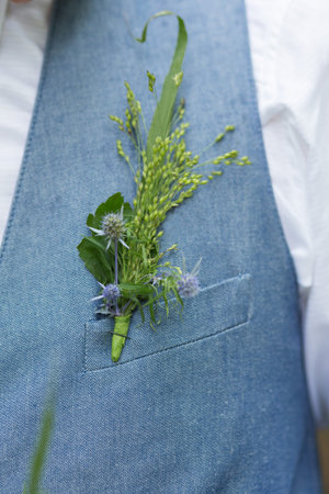 Green beautiful boutonniere on blue groom's suitの写真素材