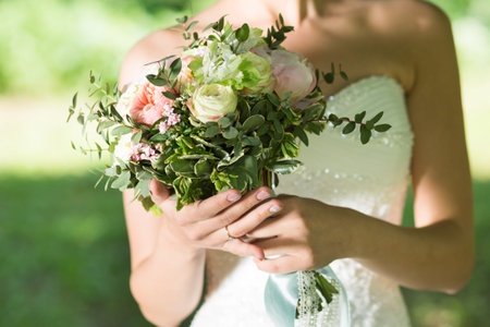 Beautiful wedding bouquet in the hands of the brideの写真素材