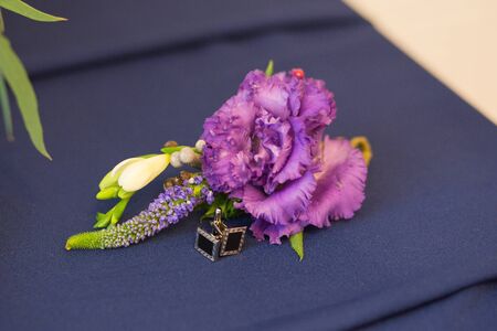 Boutonniere and cufflinks are on the groom's suitの写真素材