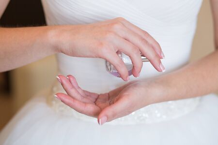 bride applying gentle perfume on her wristの写真素材
