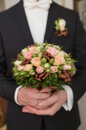 groom hold wedding bouquet in his handの写真素材