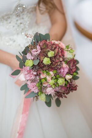 Beautiful wedding bouquet in hands of the brideの写真素材