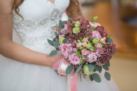 Beautiful wedding bouquet in hands of the brideの写真素材