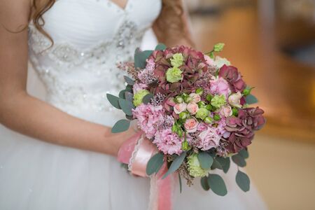 Beautiful wedding bouquet in hands of the brideの写真素材
