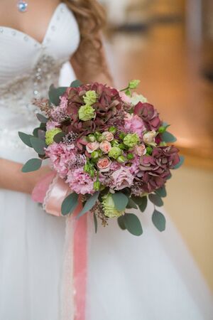 Beautiful wedding bouquet in hands of the brideの写真素材