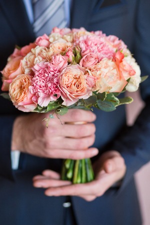 groom hold wedding bouquet in his handの写真素材