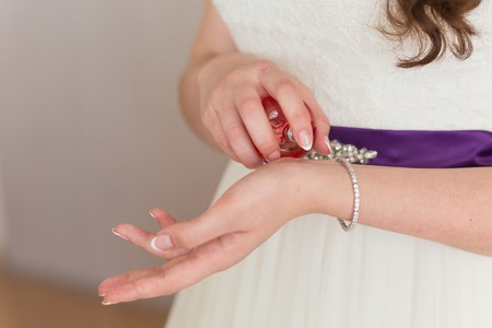 bride applying gentle perfume on her wristの写真素材