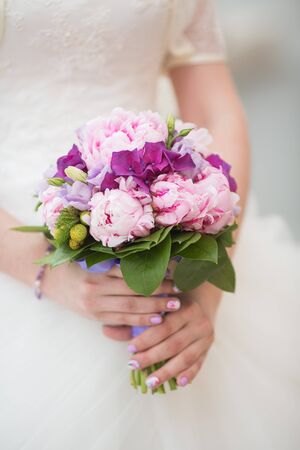 Beautiful wedding bouquet in hands of the brideの写真素材