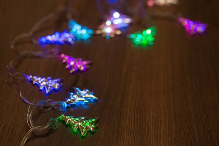 Christmas warm gold garland lights on wooden rustic backgroundの写真素材