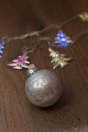 wooden table with defocused christmas  lights and glass ballsの写真素材