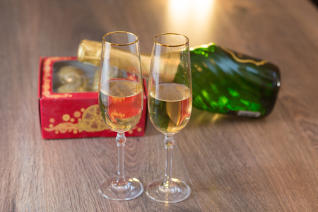 Glasses of champagne with gift box with Christmas ballsの写真素材