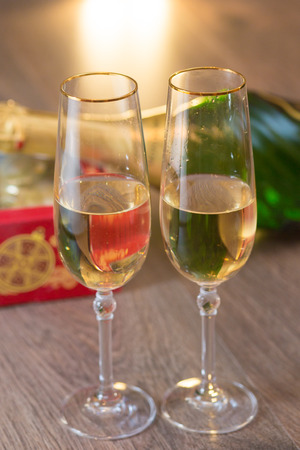 Glasses of champagne with gift box with Christmas ballsの写真素材