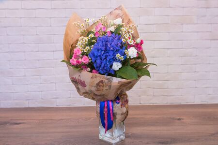 Beautiful flower bouquets on a light background of a brickの写真素材