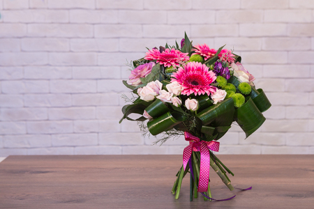 Beautiful flower bouquets on a light background of a brickの写真素材