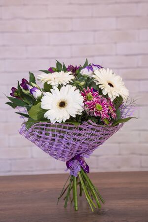 Beautiful flower bouquets on a light background of a brickの写真素材