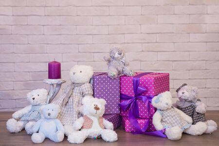 Seated teddy bear with gift boxes, over a light backgroundの写真素材