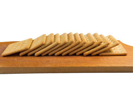 Cracker in a wooden cutting board isolated on whiteの写真素材