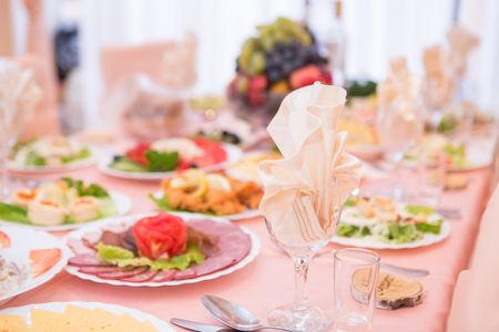 Table served with tasty meals covered with white clothの写真素材