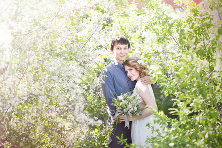 Love couple standing among blooming apple tree, springの写真素材
