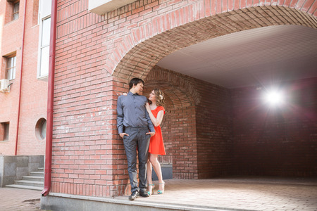 Couple in love kissing laughing having fun. Dating interracial young couple embracing on date. Pretty spring sunny outdoor portrait of young stylish couple while kissing on the street. Relationshipsの写真素材