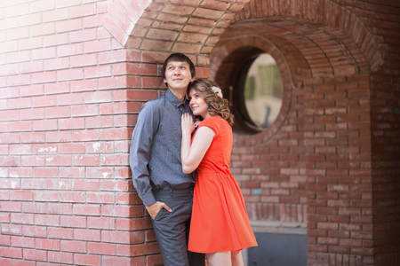 Couple in love kissing laughing having fun. Dating interracial young couple embracing on date. Pretty spring sunny outdoor portrait of young stylish couple while kissing on the street. Relationshipsの写真素材