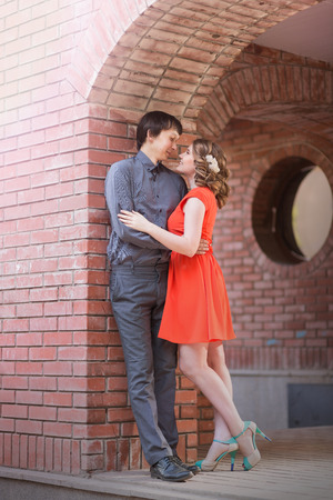 Couple in love kissing laughing having fun. Dating interracial young couple embracing on date. Pretty spring sunny outdoor portrait of young stylish couple while kissing on the street. Relationshipsの写真素材