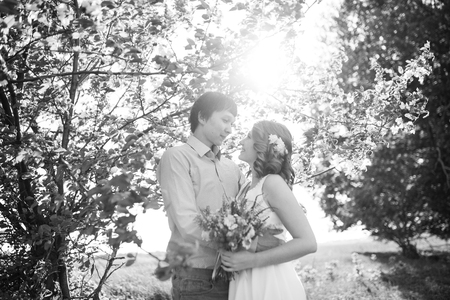 Love couple standing among blooming apple tree, spring. Black and whiteの写真素材