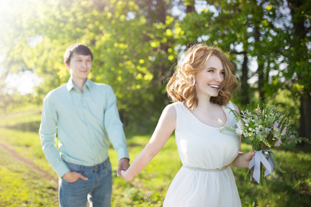 Young couple in love walking in the spring park holding handsの写真素材