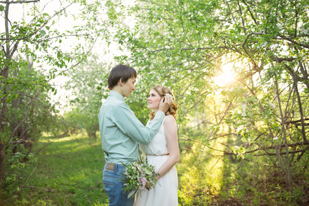 Love couple standing among blooming apple tree, springの写真素材