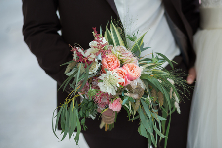 groom hold wedding bouquet in his handの写真素材
