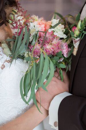 Beautiful wedding bouquet in hands of the brideの写真素材